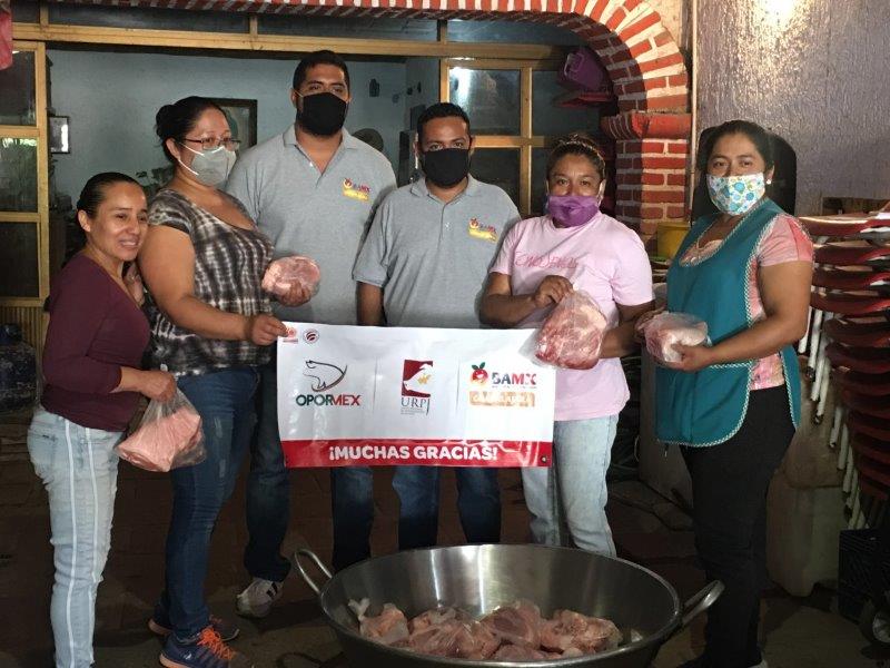 San Antonio, DiPietre y OPORMEX depositan carne de cerdo y reciben sonrisas de agradecimiento.